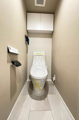 トイレ　トイレ／手洗器付タンクレストイレ・吊戸棚付、ポーチ側に窓があります。