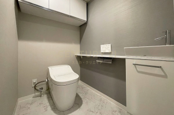 トイレ　トイレ／来客時にも使いやすい手洗いカウターあり。温水洗浄機能付きのタンクレストイレ。背面上部にはたっぷりとした収納も贅沢な空間。