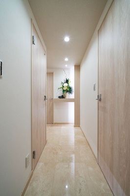 玄関　玄関ホール／玄関廊下の床は天然大理石張りで高級感があります。廊下正面には照明付きニッチカウンターがあり、季節のお花などを飾れます。