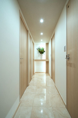 玄関　玄関ホール／玄関・廊下の床は大理石貼りで高級感があります。廊下正面には間接照明のあるニッチカウンターを設置しています。